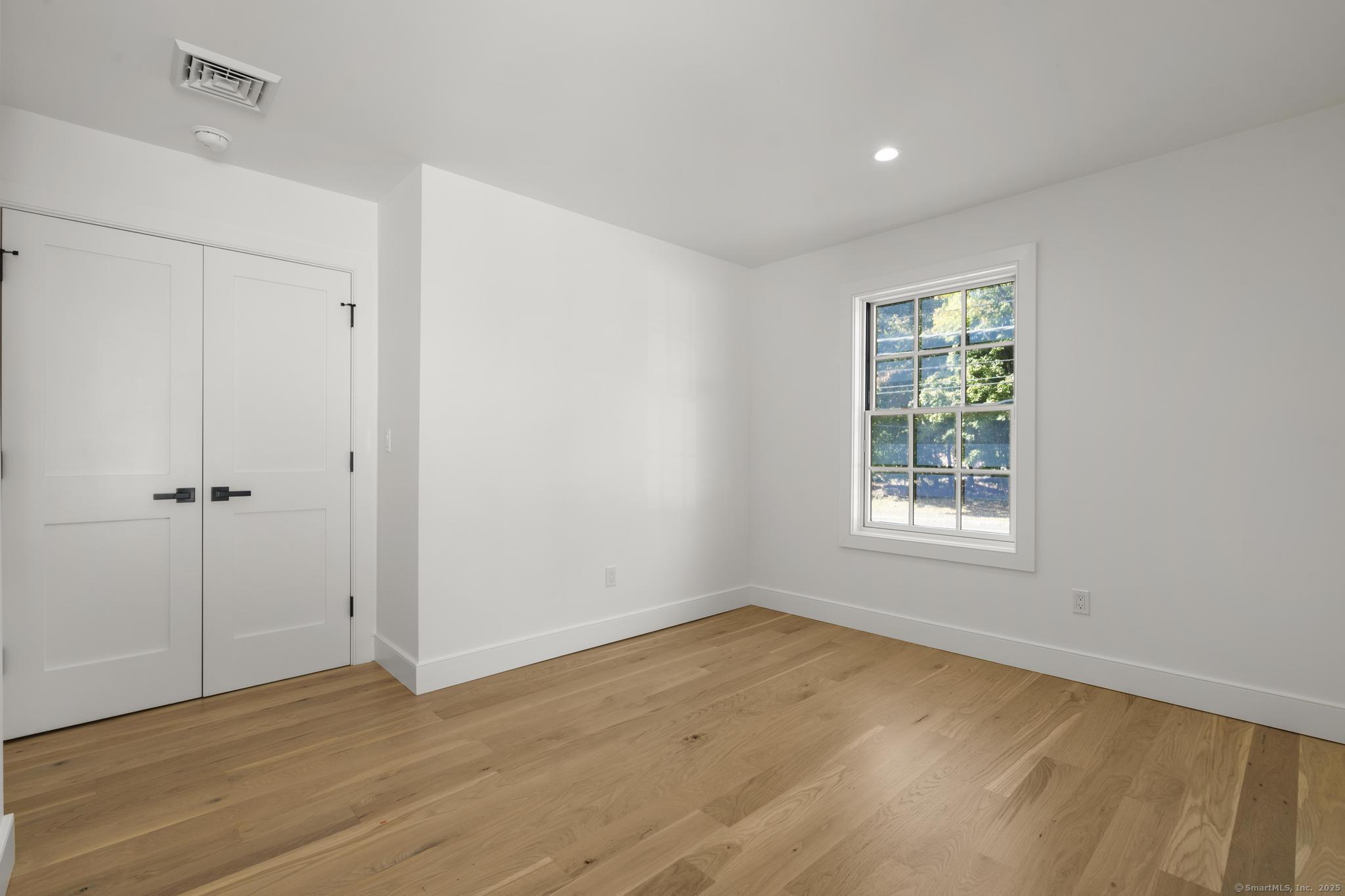 18 Sound Beach Avenue Greenwich, CT 06870 - Photo 13 of 36 a view of an empty room with wooden floor and a window