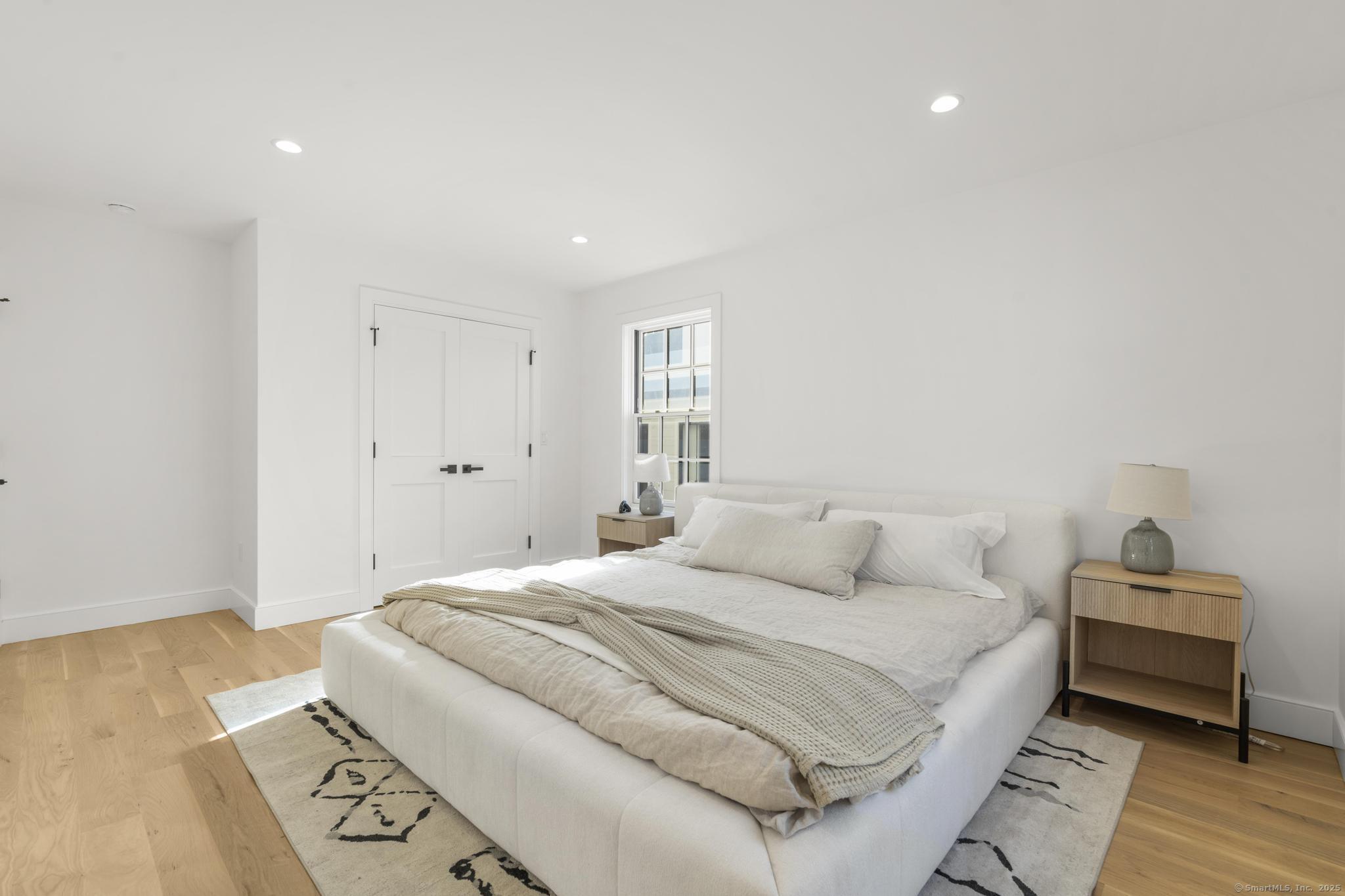 18 Sound Beach Avenue Greenwich, CT 06870 - Photo 17 of 36 a bedroom with a bed and wooden floor