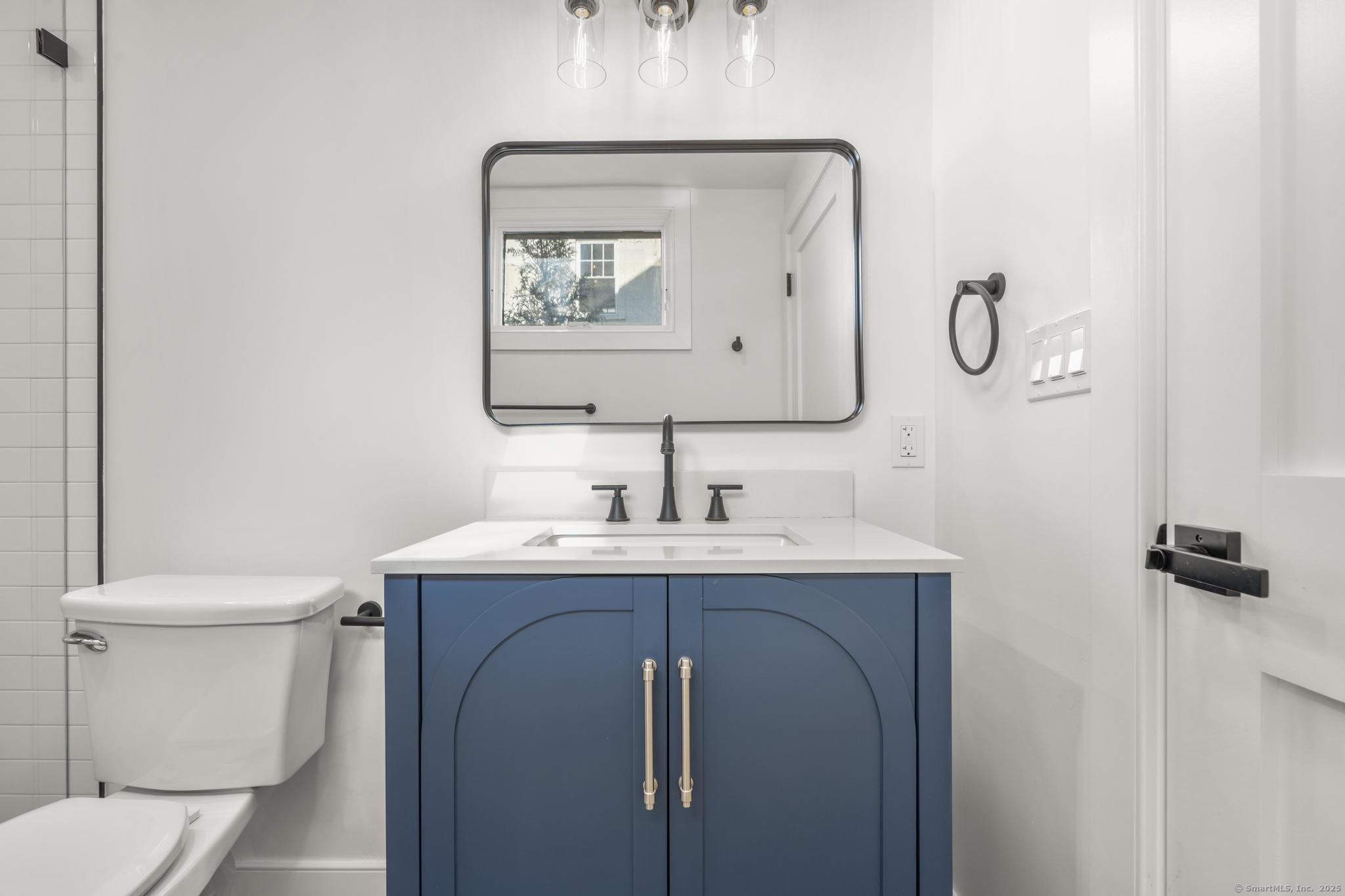 18 Sound Beach Avenue Greenwich, CT 06870 - Photo 25 of 36 a bathroom with a toilet sink and mirror