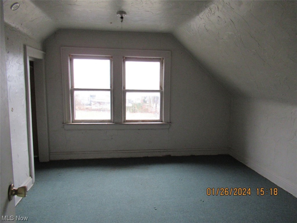 1823-1825 Reyburn Road Cleveland, OH 44112 - Photo 18 of 18 Bonus room featuring a textured ceiling, vaulted ceiling, light colored carpet, and plenty of natural light