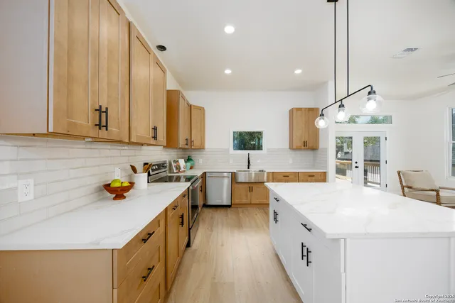 a kitchen with a sink a stove and cabinets