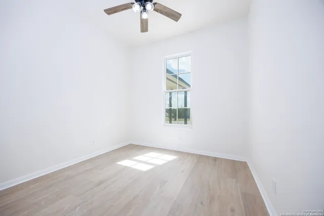 an empty room with a window and wooden floor