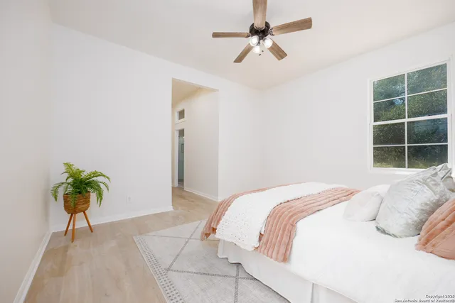 a bedroom with a bed plant and a window