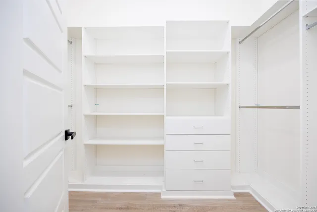a view of walk in closet with empty racks