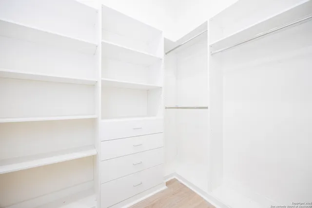 a view of walk in closet with empty racks