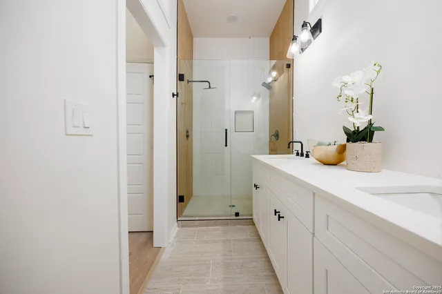 a spacious bathroom with a double vanity sink and mirror