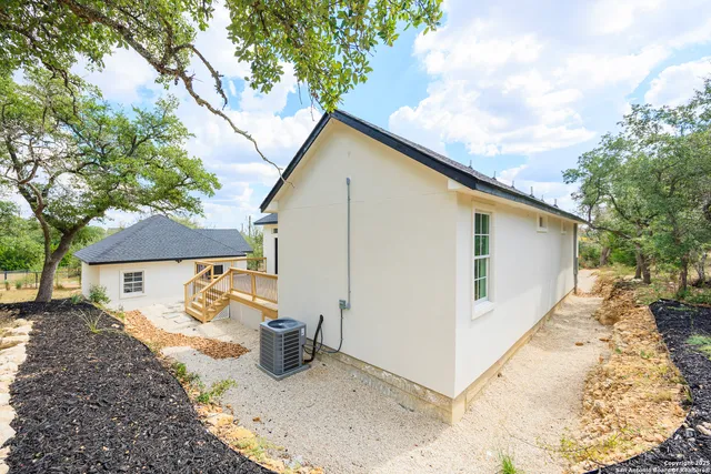 a view of a white house with a yard and large tree