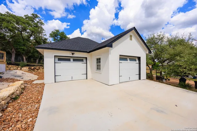 a view of white house with a yard and garage