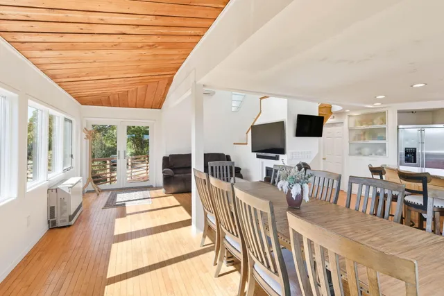 a living room with furniture a flat screen tv and kitchen view