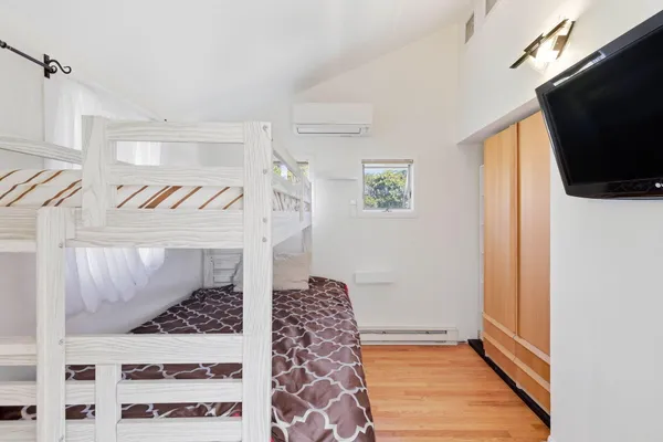 a view of a bedroom with wooden floor and a window