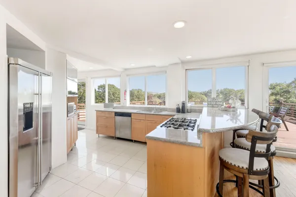 a kitchen with granite countertop wooden floor dining table and stainless steel appliances