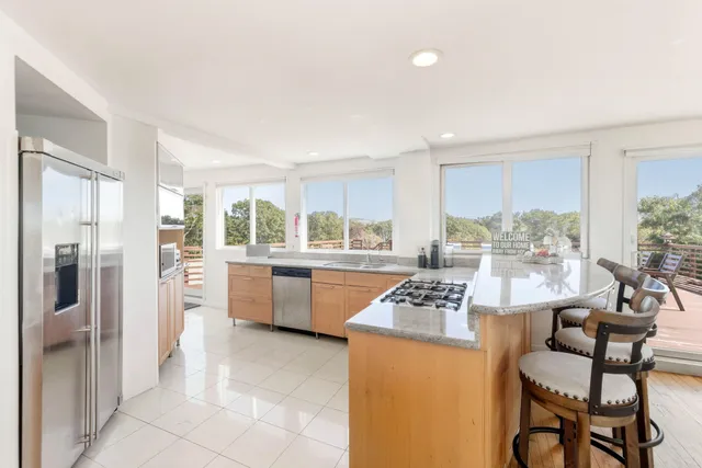 a kitchen with granite countertop wooden floor dining table and stainless steel appliances