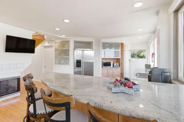 a kitchen with stainless steel appliances granite countertop a stove and a large window