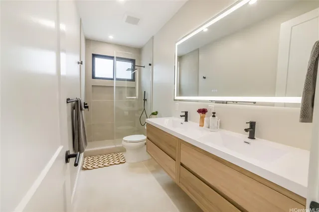 a bathroom with a shower a sink a toilet and mirror