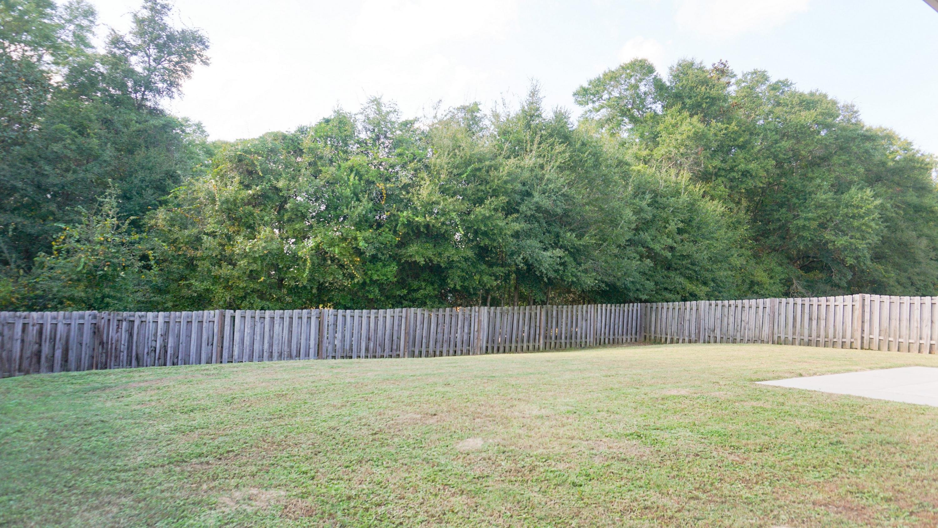 2126 Hagood Loop Crestview, FL 32536 - Photo 17 of 18 a view of a backyard with swimming pool and wooden fence