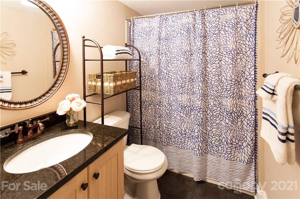 4913 Park Road, Unit D Charlotte, NC 28209 - Photo 11 of 32 a bathroom with a granite countertop sink toilet and a mirror