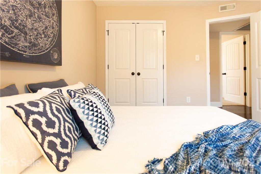 4913 Park Road, Unit D Charlotte, NC 28209 - Photo 13 of 32 a bedroom with a bed and a painting on the wall