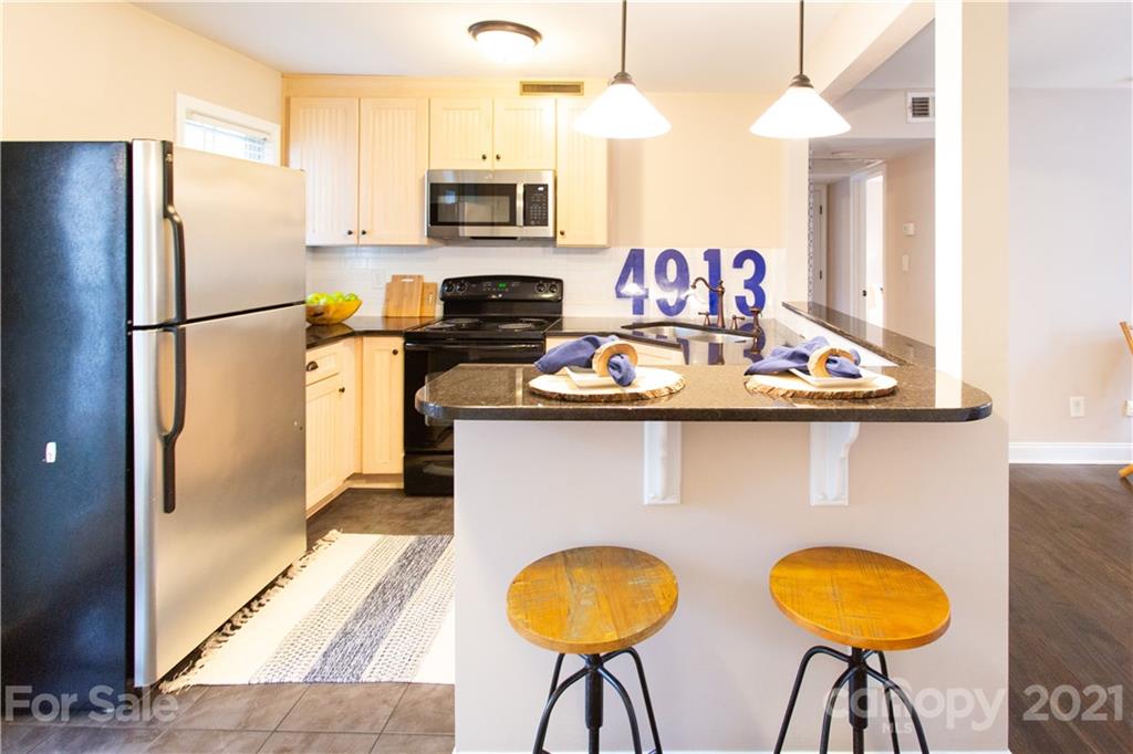 4913 Park Road, Unit D Charlotte, NC 28209 - Photo 5 of 32 a kitchen with stainless steel appliances granite countertop a sink a stove and a refrigerator