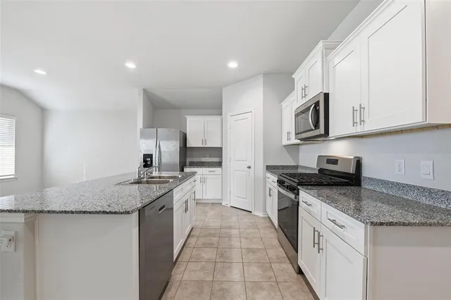 a kitchen with stainless steel appliances granite countertop a sink stove and cabinets
