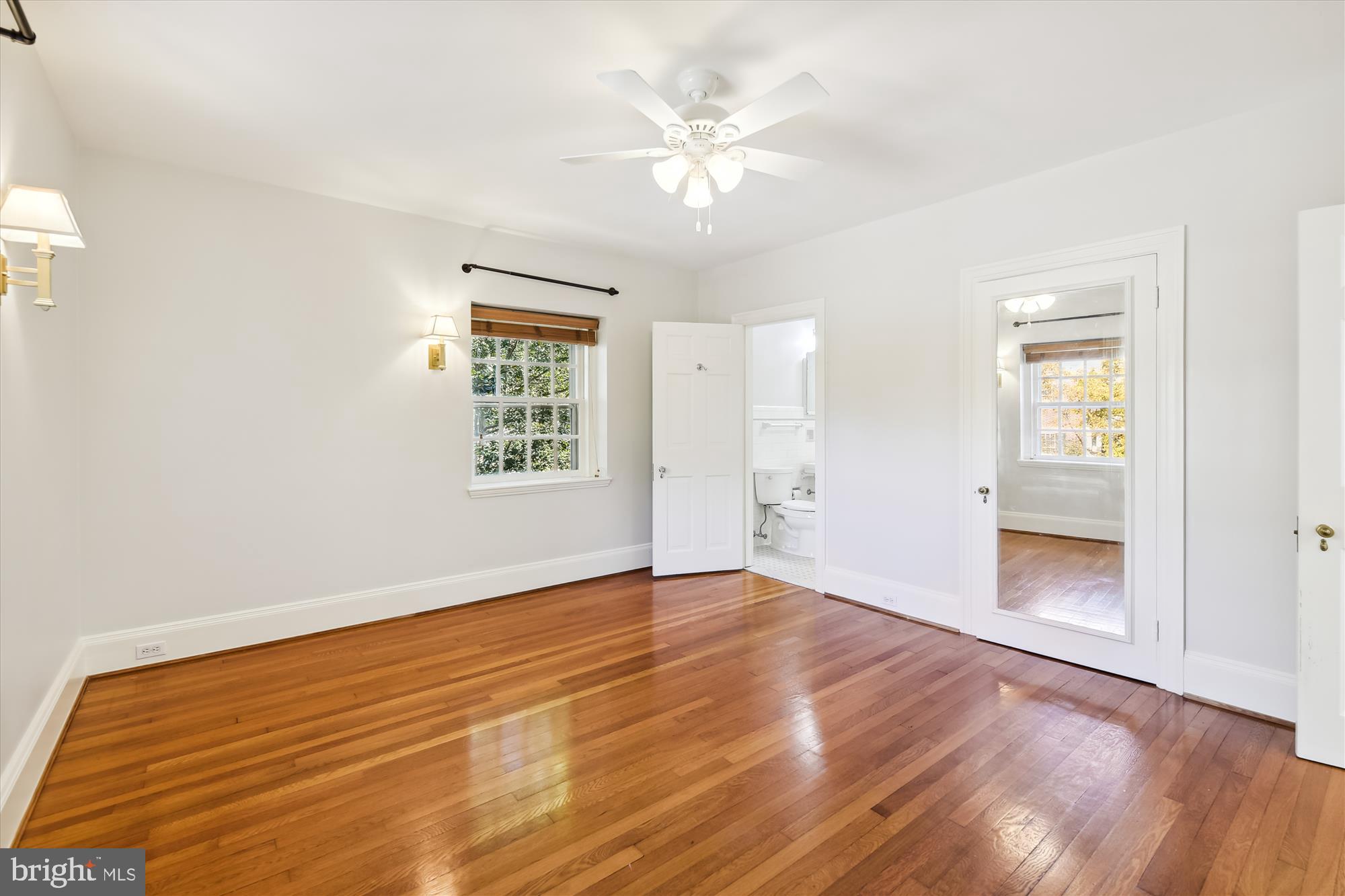 117 Upnor Road Baltimore, MD 21212 - Photo 18 of 32 an empty room with wooden floor chandelier fan and windows