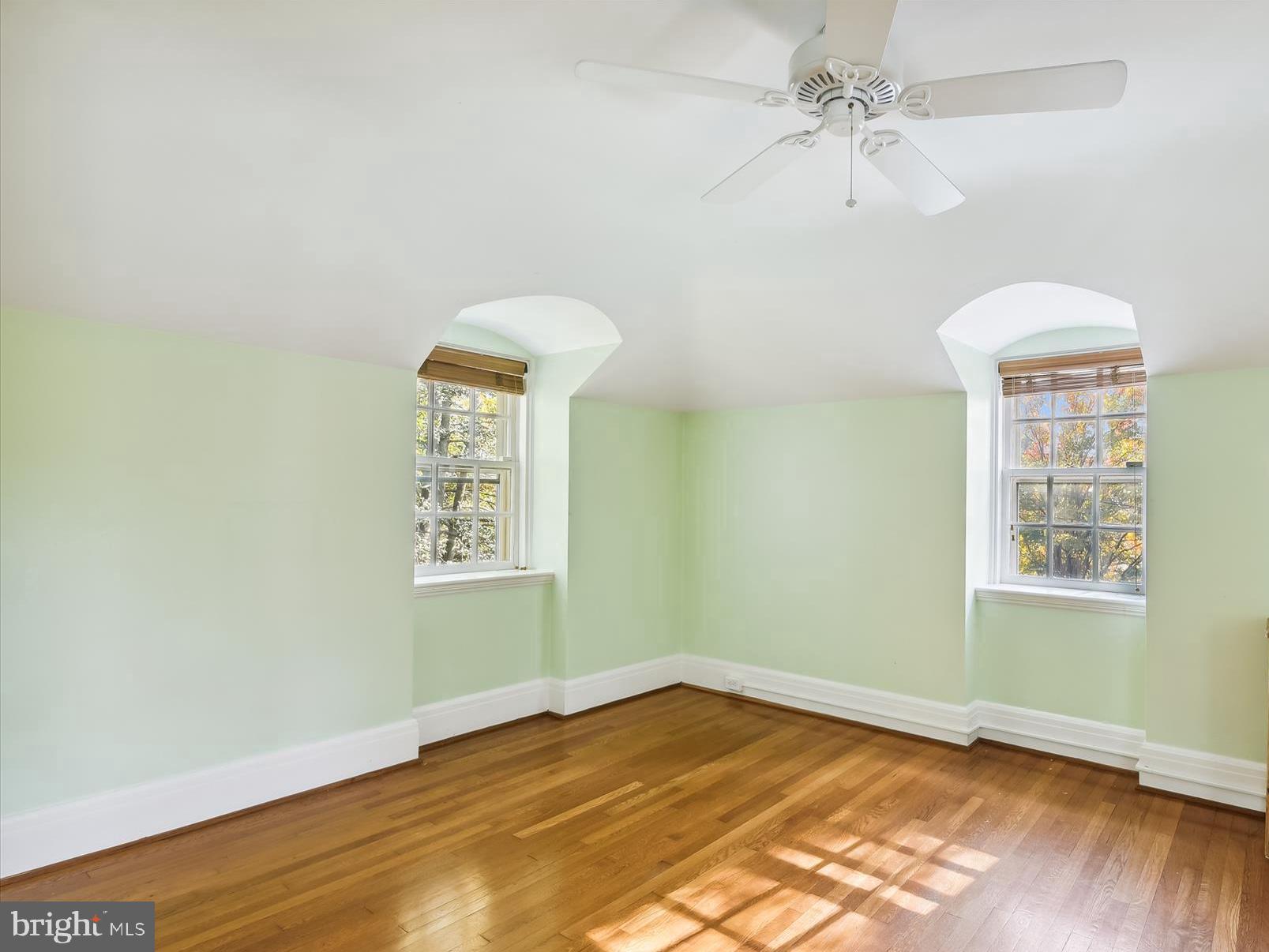 117 Upnor Road Baltimore, MD 21212 - Photo 22 of 32 an empty room with wooden floor chandelier fan and windows