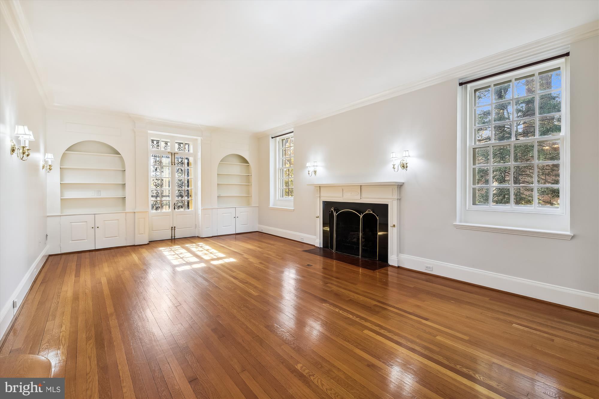 117 Upnor Road Baltimore, MD 21212 - Photo 5 of 32 an empty room with windows fireplace and wooden floor