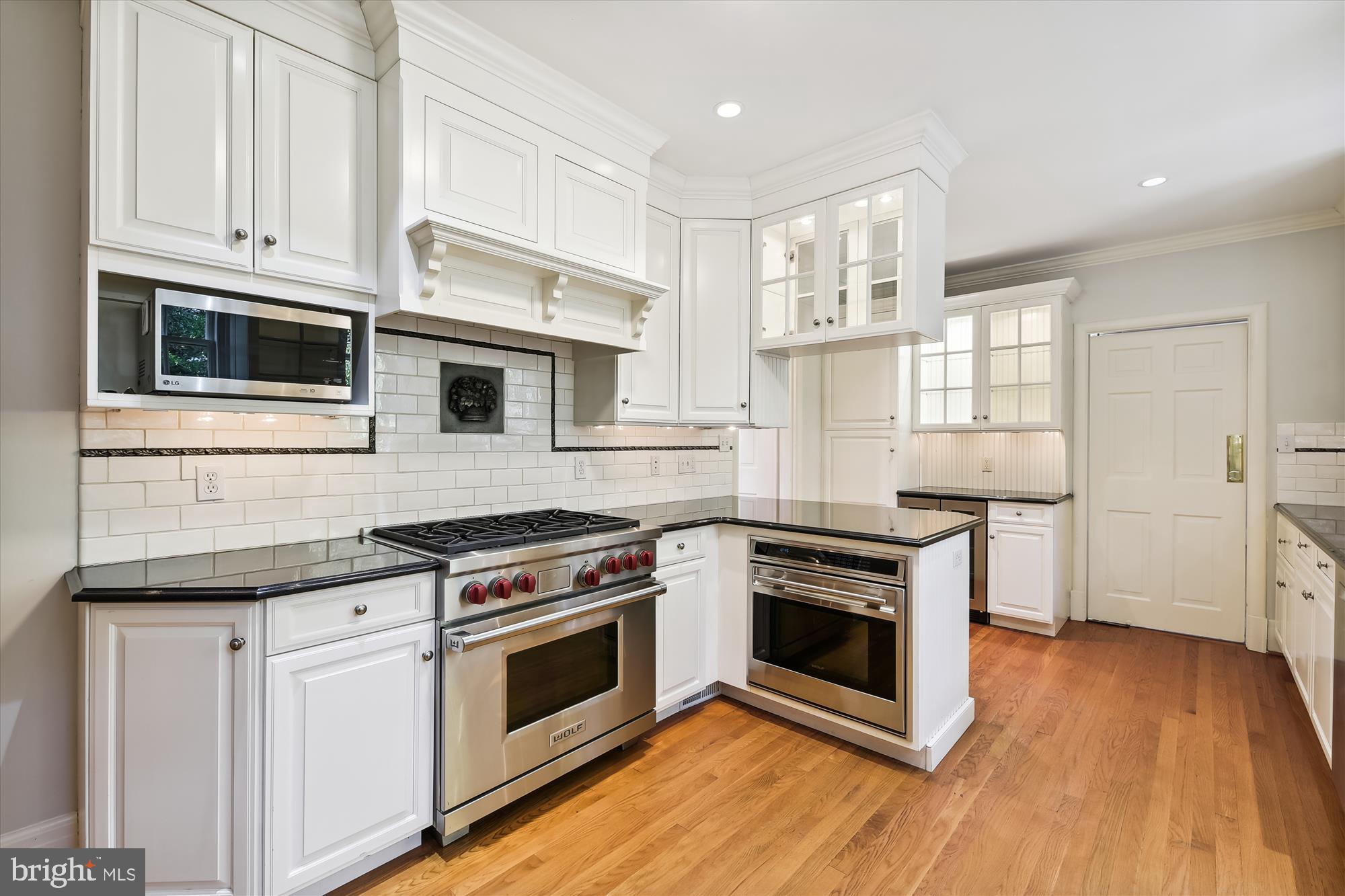 117 Upnor Road Baltimore, MD 21212 - Photo 9 of 32 a kitchen with cabinets stainless steel appliances and wooden floor