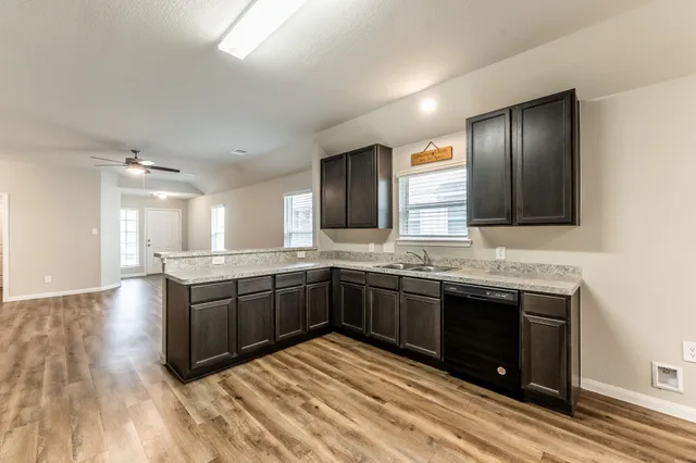 a kitchen with stainless steel appliances granite countertop a sink and wooden cabinets