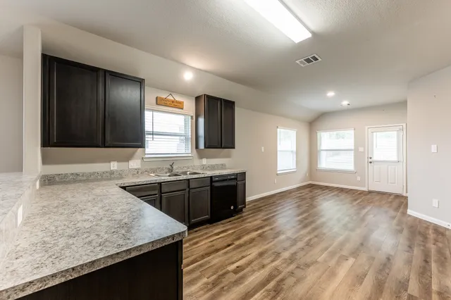 a kitchen with granite countertop a stove and a sink
