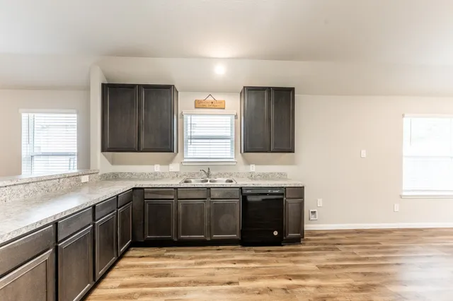 a kitchen with stainless steel appliances granite countertop a sink stove and cabinets