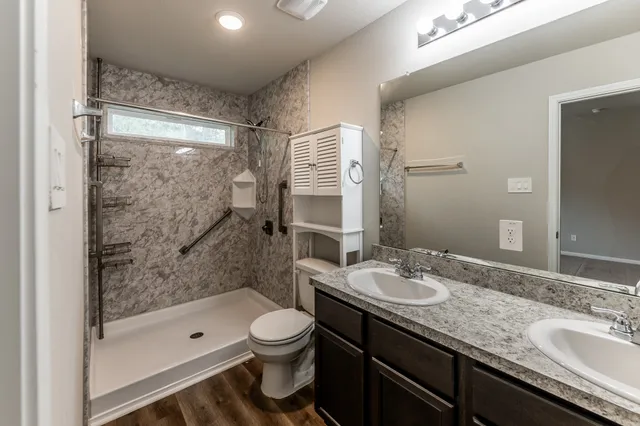a bathroom with a granite countertop sink toilet and shower
