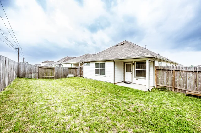 a white house sitting in middle of the grass