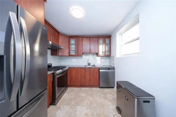 a kitchen with stainless steel appliances granite countertop a refrigerator sink and stove