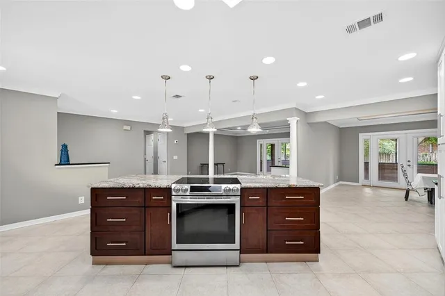 a kitchen with stainless steel appliances granite countertop white cabinets and a window