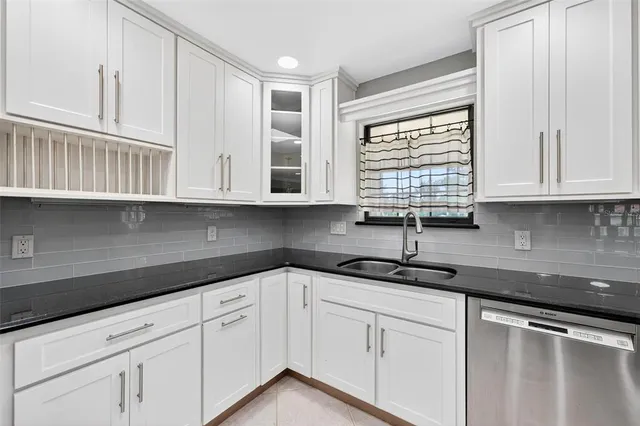 a kitchen with stainless steel appliances granite countertop a sink a stove and a wooden floors