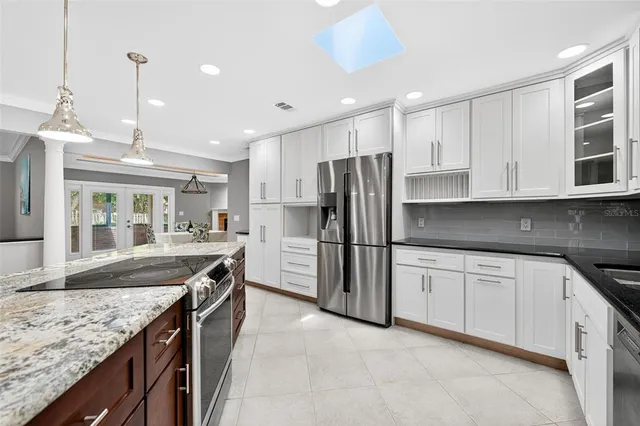 a kitchen with stainless steel appliances granite countertop a sink refrigerator and microwave