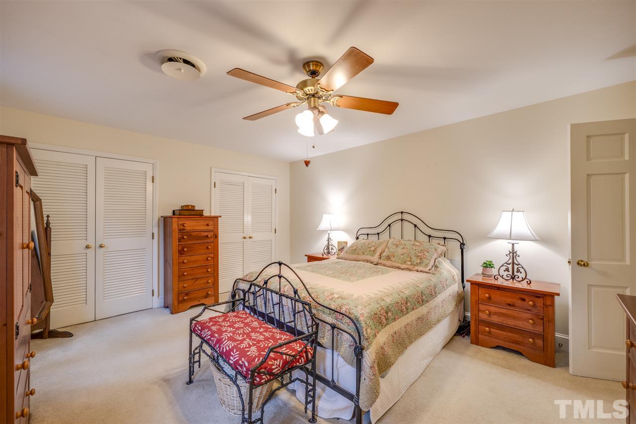 4616 Fernham Place Raleigh, NC 27612 - Photo 13 of 26 a bedroom with furniture a bed and a chandelier