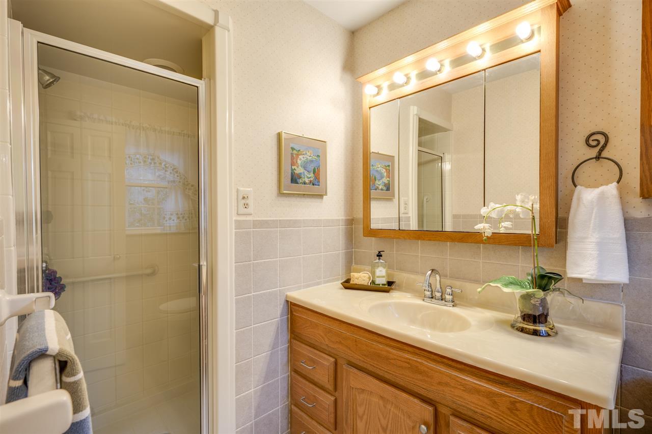 4616 Fernham Place Raleigh, NC 27612 - Photo 14 of 26 a bathroom with a granite countertop sink and a mirror