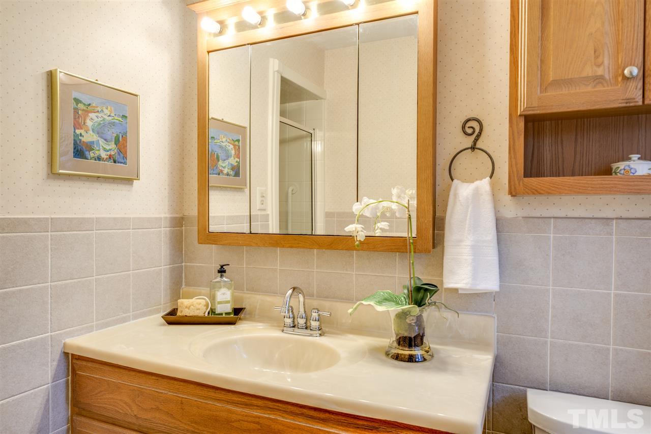 4616 Fernham Place Raleigh, NC 27612 - Photo 15 of 26 a bathroom with a sink and a mirror