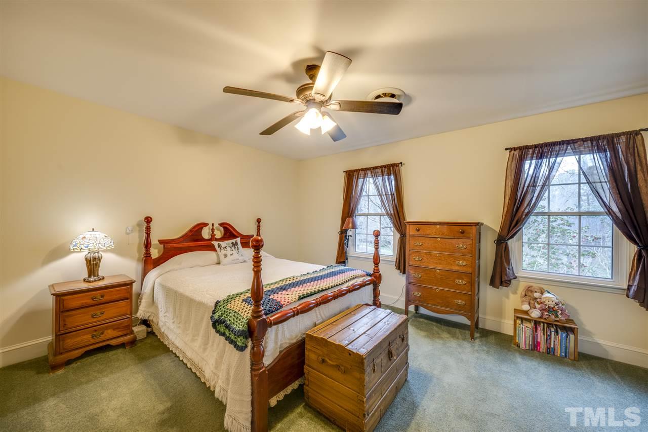 4616 Fernham Place Raleigh, NC 27612 - Photo 18 of 26 a bedroom with a bed and a chandelier
