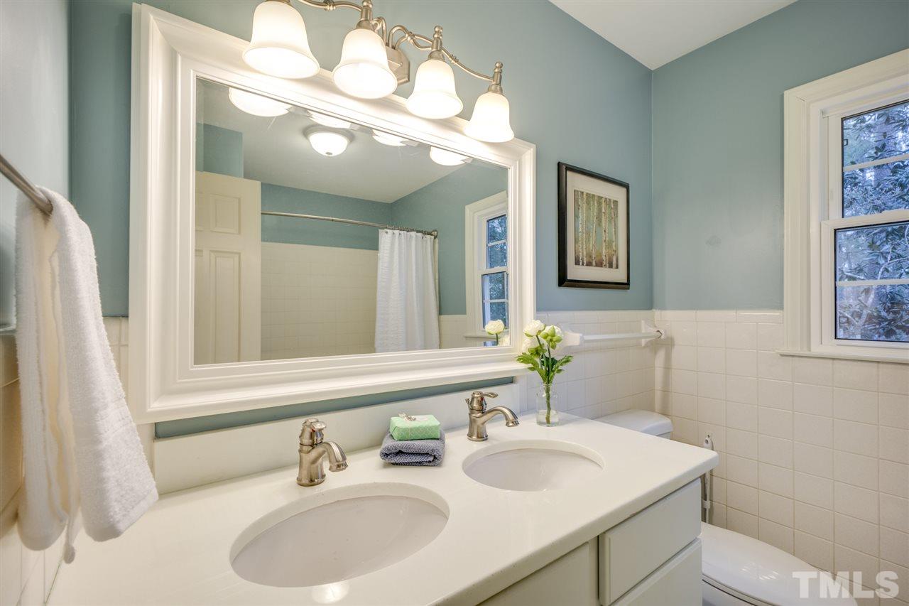 4616 Fernham Place Raleigh, NC 27612 - Photo 19 of 26 a bathroom with a sink and a mirror