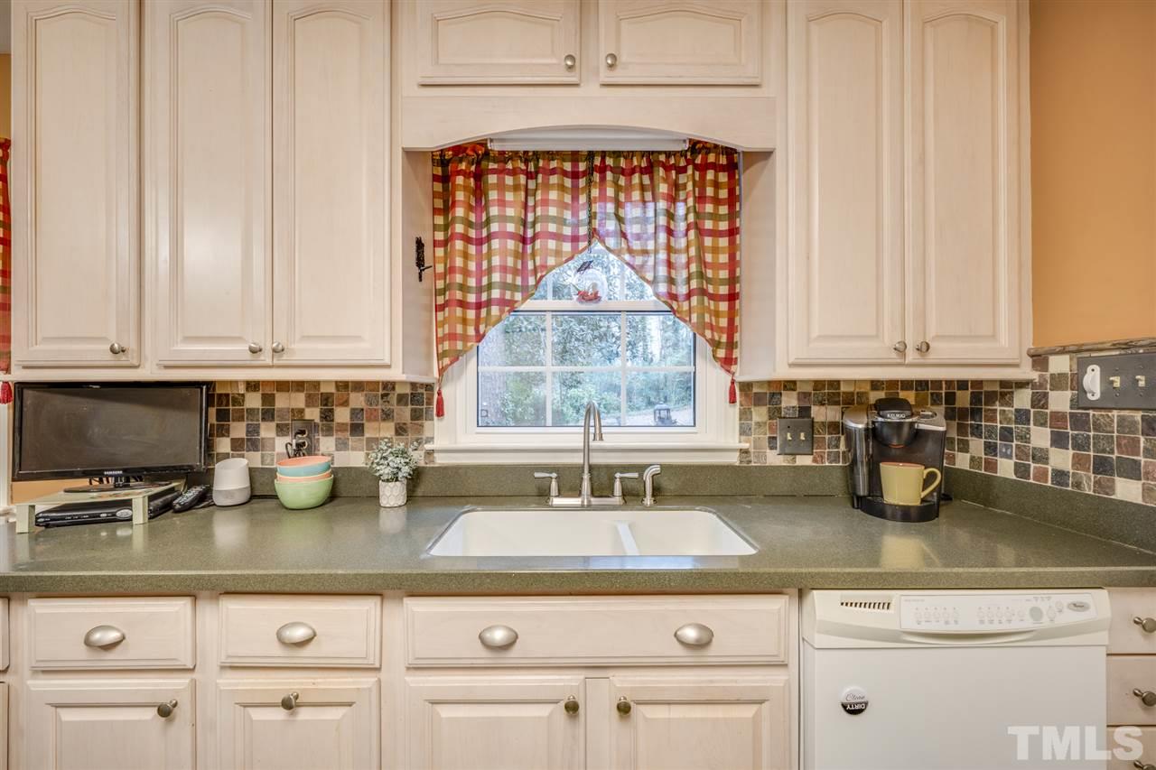 4616 Fernham Place Raleigh, NC 27612 - Photo 4 of 26 a kitchen with white cabinets and a window