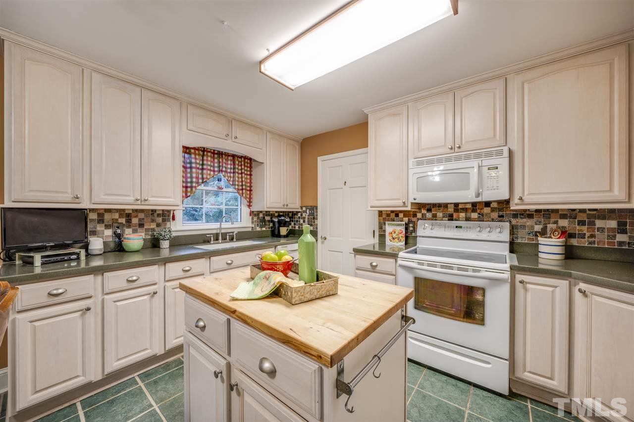 4616 Fernham Place Raleigh, NC 27612 - Photo 7 of 26 a kitchen with white cabinets and white appliances