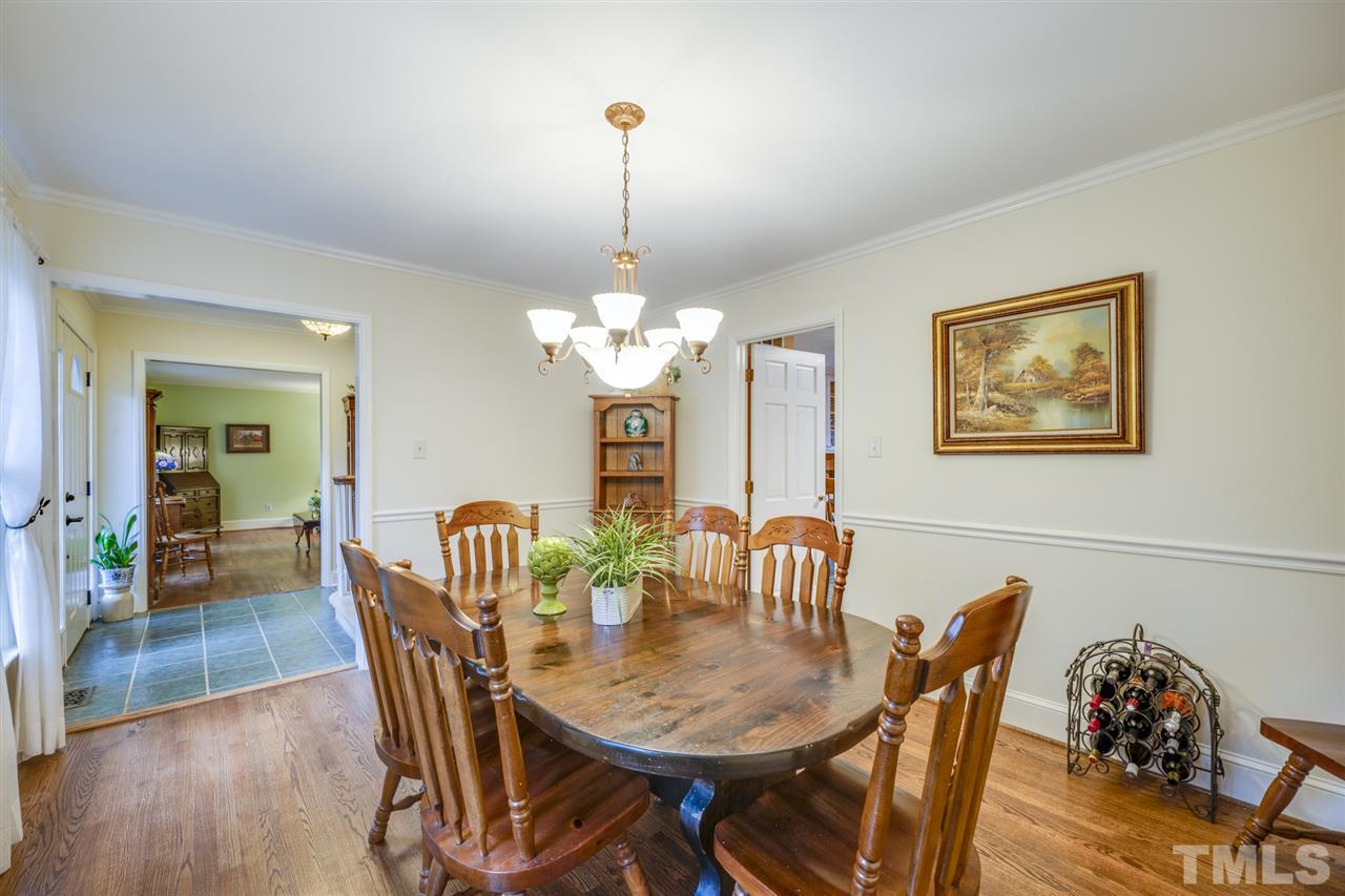 4616 Fernham Place Raleigh, NC 27612 - Photo 9 of 26 a view of a dining room with furniture wooden floor and a chandelier