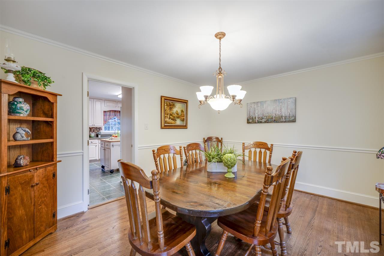 4616 Fernham Place Raleigh, NC 27612 - Photo 10 of 26 a view of a dining room with furniture a chandelier and wooden floor
