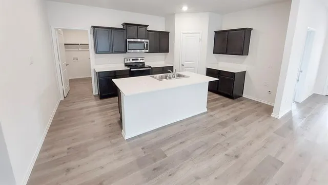 a view of kitchen with kitchen island microwave and stove