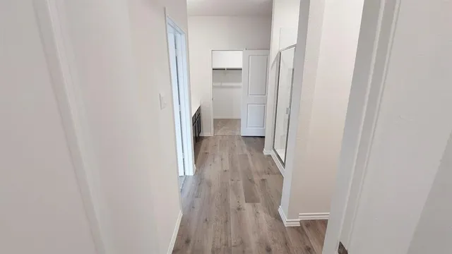 a view of a hallway with wooden floor and a hallway