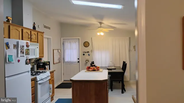 a view of a dining room with furniture and a chandelier fan