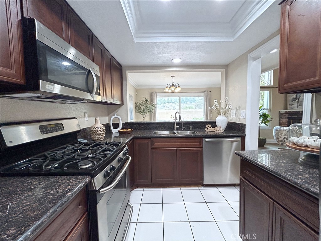 555 Canyon Hill Road San Dimas, CA 91773 - Photo 4 of 16 a kitchen with a stove a sink and a microwave
