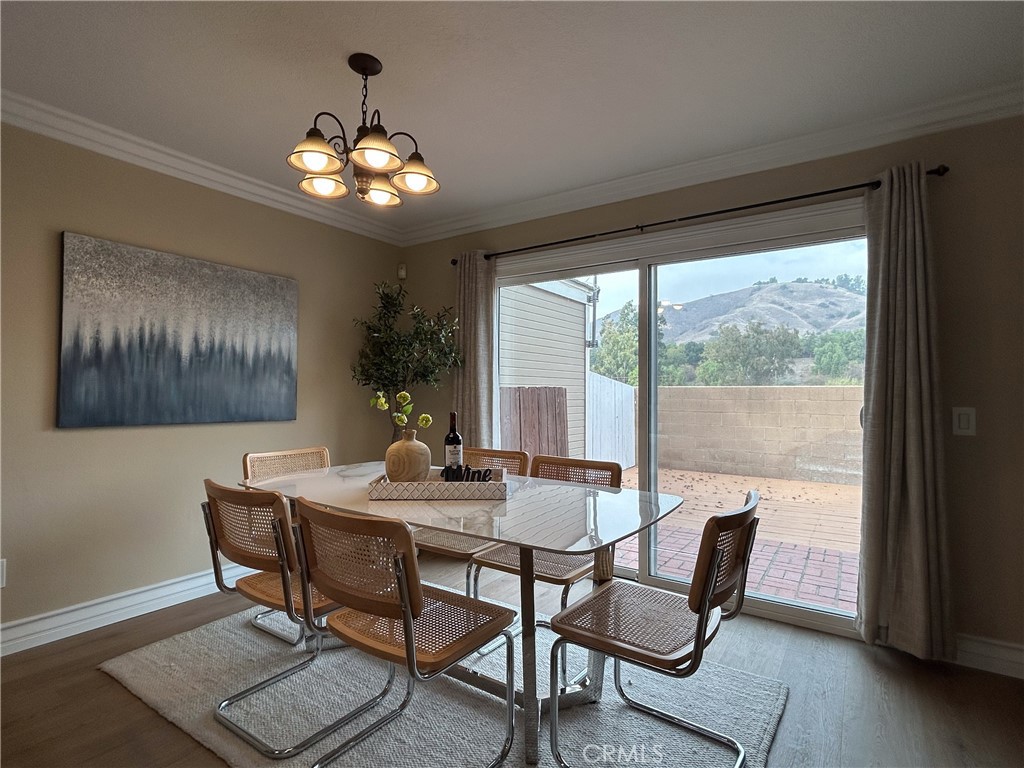555 Canyon Hill Road San Dimas, CA 91773 - Photo 8 of 16 a dining room with wooden floor a chandelier a glass table and chairs